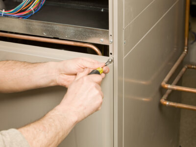 Furnace Tune Up: Repair Technician Removing Furnace Service Panel