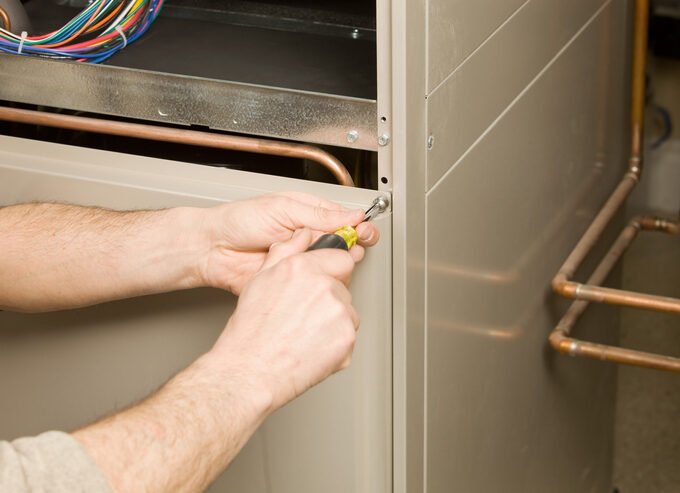 Furnace Tune Up: Repair Technician Removing Furnace Service Panel