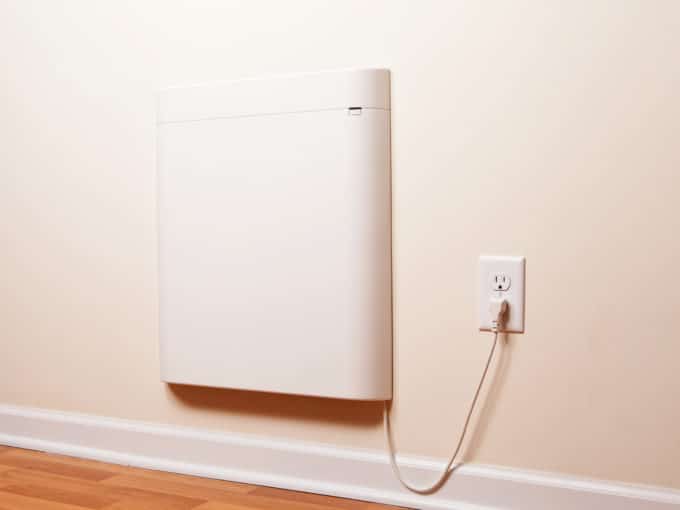 A wall-mounted electric convection heater in a house room. This particular installation acts as supplemental heat when temperatures get very cold outside. This heater is very energy efficient, air is drawn up from the bottom and rises across a heating panel out the top without the use of a fan.